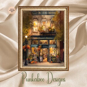 May include: A framed watercolor print of a bookstore at dusk. The shop has a teal awning and is filled with books and warm lighting. Pumpkins and fall foliage decorate the entrance. The frame is gold and the print is labeled "Digital Download Only."