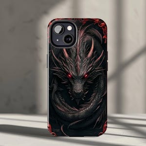 May include: Black phone case featuring a detailed illustration of a dragon. The dragon has red eyes and accents, with a dark background. The case has a glossy finish and a protective design.