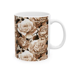 May include: White ceramic coffee mug featuring a repeating pattern of sepia-toned roses. The floral design covers the entire surface of the mug, creating a vintage aesthetic. The mug has a standard handle for easy gripping.