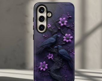 May include: A black phone case with a purple floral design and two black birds. The case has a raised camera bump with three lenses.