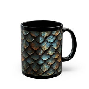 May include: Black ceramic coffee mug with a dragon scale pattern in shades of blue, teal, and bronze. The mug has a black interior and handle, and is suitable for hot or cold beverages.