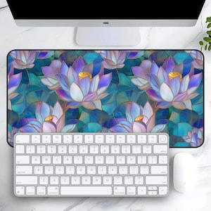 May include: A blue and purple floral mousepad with a stained glass design featuring lotus flowers. The mousepad is on a white surface with a keyboard and mouse.