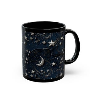 May include: Black ceramic mug with a celestial design. The mug features a dark blue background with silver stars, a crescent moon, and swirling patterns. The handle and interior of the mug are black.
