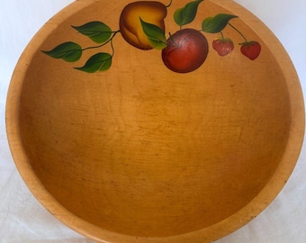 May include: A round, light-colored wooden bowl featuring a hand-painted design along the inner rim. The artwork depicts a yellow-orange fruit, a deep red fruit, and two small red strawberries, all connected by green leaves and thin stems.