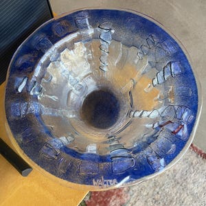 Può includere: Una ciotola di vetro trasparente con un bordo ampio e svasato e un bordo blu scuro. La ciotola presenta un design strutturato con accenti blu e trasparenti. Il nome "Walter" è inciso sul lato. La ciotola è su una superficie di legno.