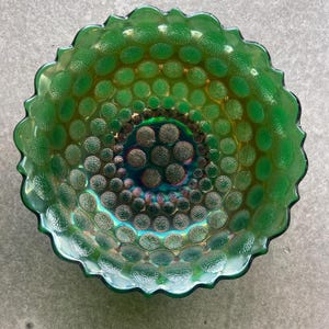May include: A green iridescent glass bowl with a scalloped edge and a textured surface of small raised circles.