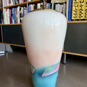 以下が含まれることがあります： 白の上部からピンク、そして青へとグラデーションする、背の高いセラミックテーブルランプ。真鍮製のネックとカラフルな抽象的なデザインが特徴です。ランプの高さは約61cmです。