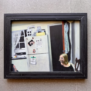 May include: Oil painting in a black frame depicting a kitchen scene. A white refrigerator with magnets and a window with a white curtain are visible. A person is seated at a table, and another person is partially visible.
