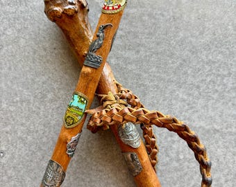 Bastones de senderismo con correas de cuero y medallas de alfiler, típicos del arte popular alemán de los años 70.