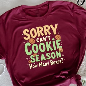 A funny and playful t-shirt for kids featuring the phrase "Cookie Dealer Scout for Girls Sorry Can’t Cookie Season." Perfect for young Girl Scouts or kids who love cookies and have a sense of humor. Ideal for cookie season or casual wear.