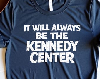 Könnte beinhalten: Marineblaues T-Shirt mit dem weißen Text "IT WILL ALWAYS BE THE KENNEDY CENTER". Die Wörter sind übereinander gestapelt. Die Worte "Heather Navy" sind in Kursivschrift oben rechts geschrieben.