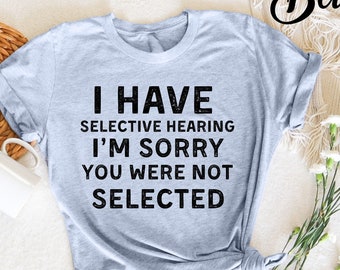 Może przedstawiać: Jasnoniebieska koszulka z nadrukiem "I have selective hearing I'm sorry you were not selected" w kolorze czarnym.