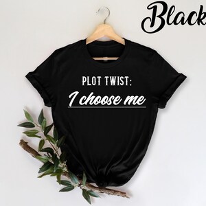 May include: Black t-shirt with the text "PLOT TWIST: I choose me" in white.