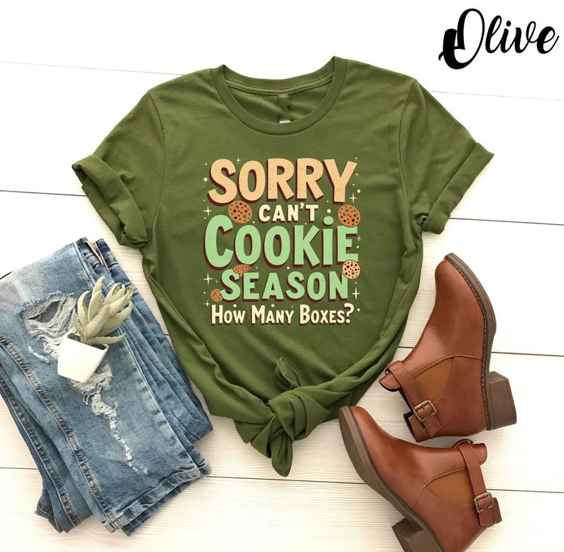 May include: Green t-shirt with the text "Sorry can't cookie season. How many boxes?" in a light green box with brown cookie images.
