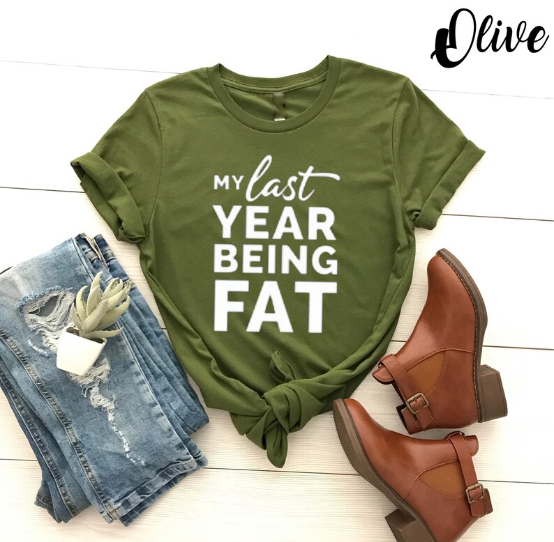 May include: A green t-shirt with the text "My last year being fat" in white letters.