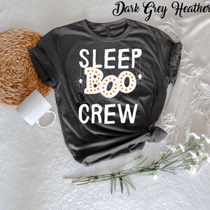 May include: Dark grey heather t-shirt with the text "SLEEP BOO CREW" in white. The word "BOO" is surrounded by orange and yellow dots and has spider webs and spiders above it.