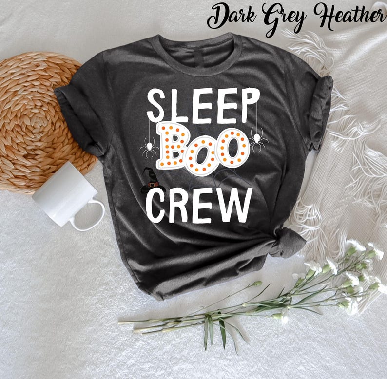 May include: Dark grey heather t-shirt with the text "SLEEP BOO CREW" in white. The word "BOO" is surrounded by orange and yellow dots and has spider webs and spiders above it.