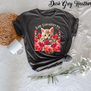 May include: Dark grey heather t-shirt featuring a graphic of a ginger kitten surrounded by red roses, with the text "Rage Consumes Me". The shirt has short sleeves and a crew neck.