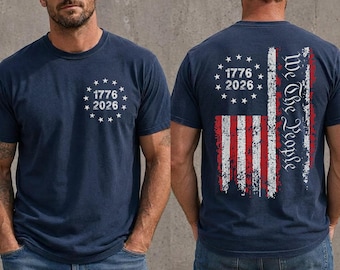 Peut inclure: Un t-shirt bleu marine à manches courtes avec un motif d'étoiles en cercle et le texte 1776 2026 sur le devant. Le dos présente un graphique du drapeau américain vieilli avec le texte We The People et un cercle d'étoiles avec 1776 2026.