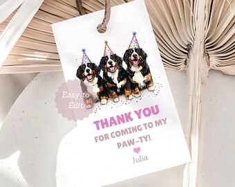 May include: A white gift tag with a brown leather string features three Bernese Mountain Dogs wearing party hats. The tag reads "THANK YOU FOR COMING TO MY PAW-TY!" with the name "Julia" below.