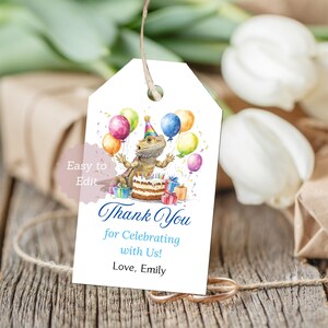 May include: A white gift tag with a watercolor illustration of a bearded dragon wearing a party hat, surrounded by balloons and a birthday cake. The tag reads "Thank You for Celebrating with Us!" and "Love, Emily".