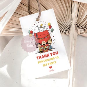 May include: White gift tag featuring Snoopy and friends celebrating a party. The tag includes the text "Thank you for coming to my party" in red and yellow, with a heart and the name "Emily". Colorful balloons and confetti decorate the tag.