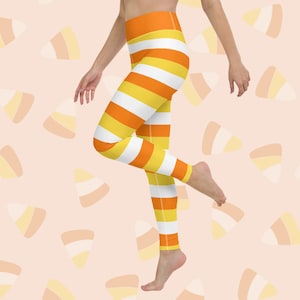 Puede incluir: Leggings de rayas naranjas y blancas con cintura alta. Los leggings tienen un patrón de maíz dulce.