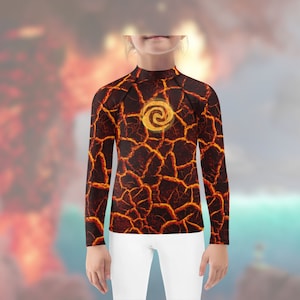 Pode incluir: Uma camisa de manga comprida com um padrão de rocha de lava e um símbolo amarelo no centro. O símbolo é uma espiral estilizada.