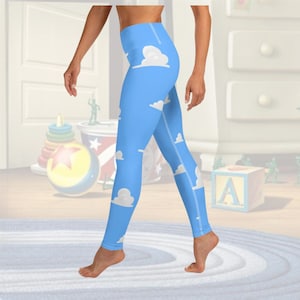 Puede incluir: Leggings de yoga azules con un patrón de nubes blancas. Los leggings son de cintura alta y tienen una silueta ajustada.