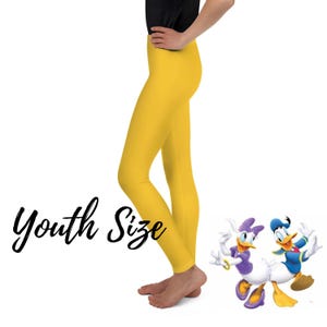 May include: Bright yellow youth size leggings. The leggings are a solid colour. The words "Youth Size" are written in black cursive script. The image also features cartoon characters Daisy Duck and Donald Duck.