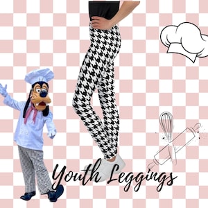 May include: Black and white houndstooth patterned youth leggings. The leggings are shown on a model wearing white trainers. The image also includes a cartoon chef character and a chef's hat.