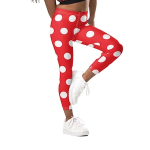 Puede incluir: Leggings rojas con estampado de lunares blancos. Las leggings son ajustadas y tienen una longitud recortada.