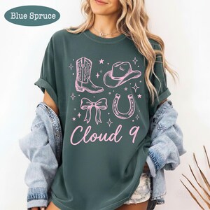 May include: A white ceramic mug with a black handle and the text "But First, Coffee" in a handwritten style. The mug is on a white surface. The mug is likely for hot beverages.