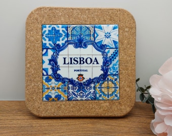 May include: Cork coaster with a blue and white tile design featuring the word "LISBOA" and "PORTUGAL" in a decorative frame.