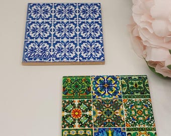 May include: Two square ceramic coasters with Portuguese tile designs. One coaster features a blue and white floral pattern, the other a colorful mosaic of floral motifs. Both have the word "Portugal" printed on them.