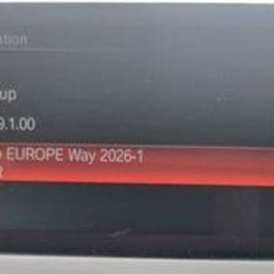 Puede incluir: Una pantalla digital muestra información de la versión para Europa, BMW Group y un mapa de carreteras. El texto resaltado dice "Road Map EUROPE Way 2026-1". La pantalla es negra con texto blanco y un resaltado rojo.