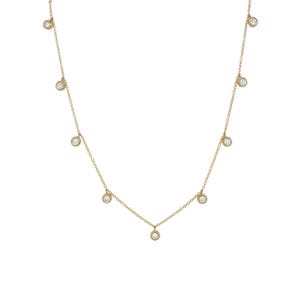 Puede incluir: Un delicado collar de oro con m&uacute;ltiples piedras preciosas redondas y transparentes engastadas en bisel. Las piedras preciosas est&aacute;n espaciadas uniformemente a lo largo de una fina cadena de oro. El collar se muestra sobre un fondo blanco.