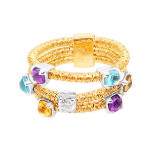 May include: A gold ring with multiple bands and colourful gemstones. The ring features a diamond, amethyst, topaz, and citrine stones. The ring is marked "ITALY" on the side.