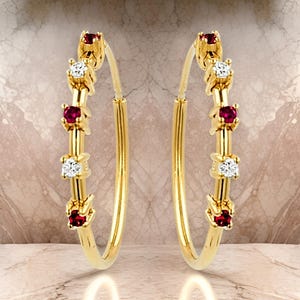 May include: Gold hoop earrings with alternating red and white gemstones. The earrings are a classic style with a modern twist.