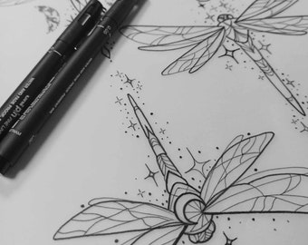 May include: Black and white line drawing of three dragonflies with a crescent moon and stars. The dragonflies are drawn in a detailed, intricate style.