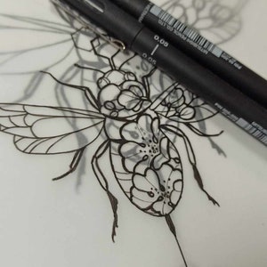 May include: A black and white line drawing of a bee with geometric shapes surrounding it. Two black pens are lying on top of the drawing. The pens are labeled "0.05" and "0.3", and "MITSUBISHI PENCIL CO. LTD."