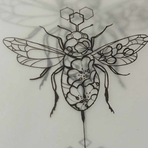May include: A black and white line drawing of a bee with floral details. The bee is surrounded by geometric shapes, resembling honeycombs.
