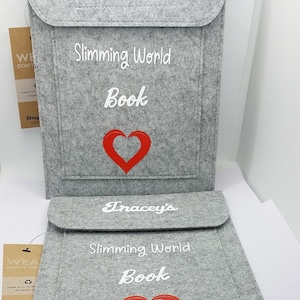May include: Two gray felt book covers with white text and a red heart. The top cover says "Emma's Slimming World Book" and the bottom cover says "Tracey's Slimming World Book".