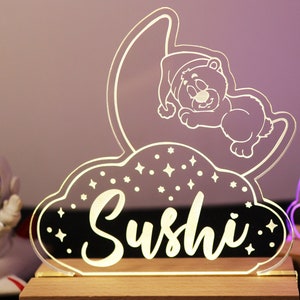 May include: A white ceramic mug with a black handle and the text "But First, Coffee" in a black, handwritten-style font. The mug is on a white surface.