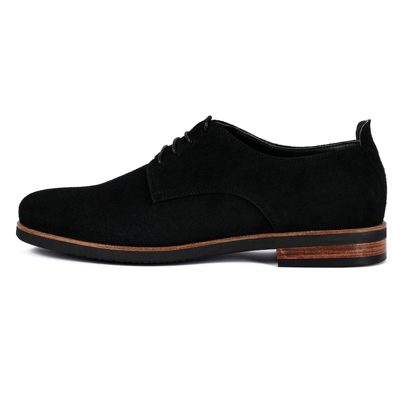 May include: Black suede leather lace-up shoes with a brown leather sole.