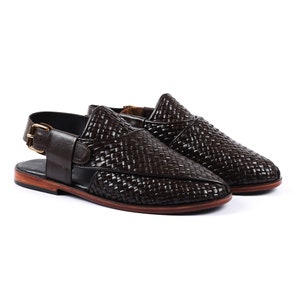 May include: A pair of brown leather woven slip-on shoes with a buckle strap on one shoe.