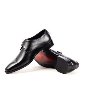 May include: A pair of black leather dress shoes with a buckle closure. The shoes are on a white background.