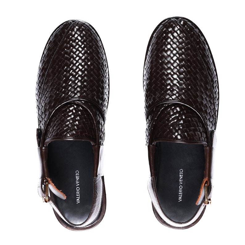 May include: A pair of brown leather woven slip-on shoes with a buckle detail. The shoes have the brand name "VALERIO VENETO" printed on the inside.