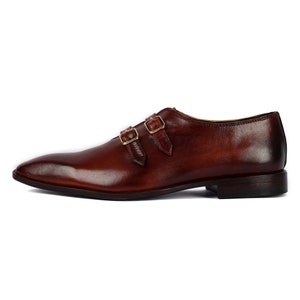 May include: Brown leather double monk strap dress shoes with gold buckles.