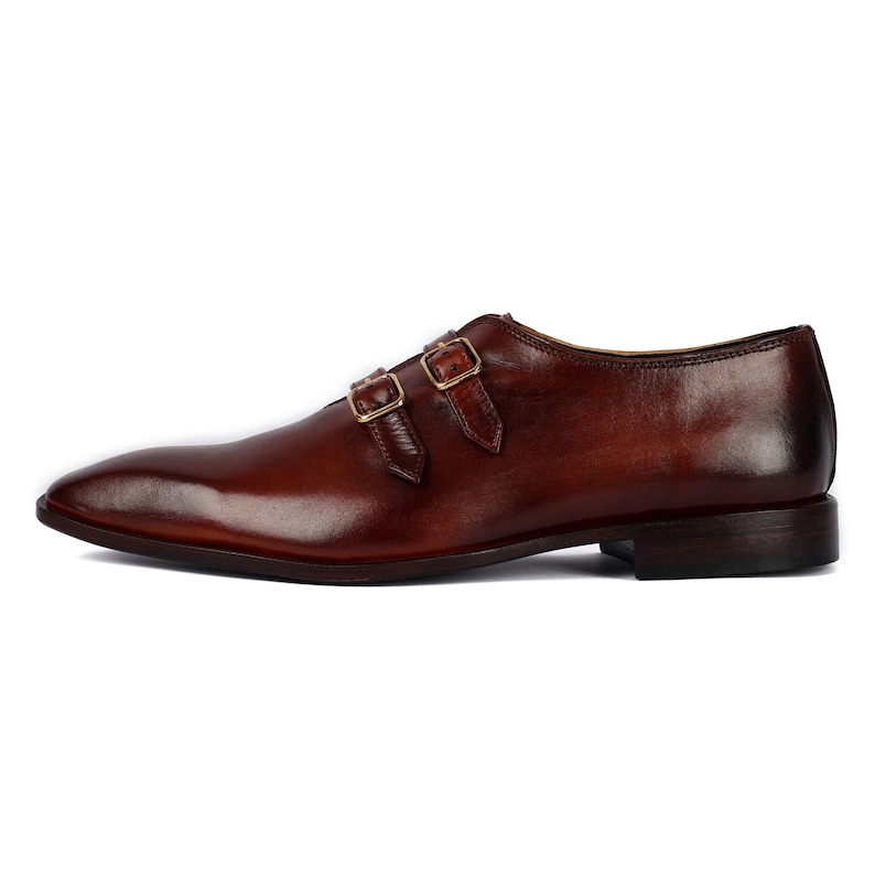 May include: Brown leather double monk strap dress shoes with gold buckles.